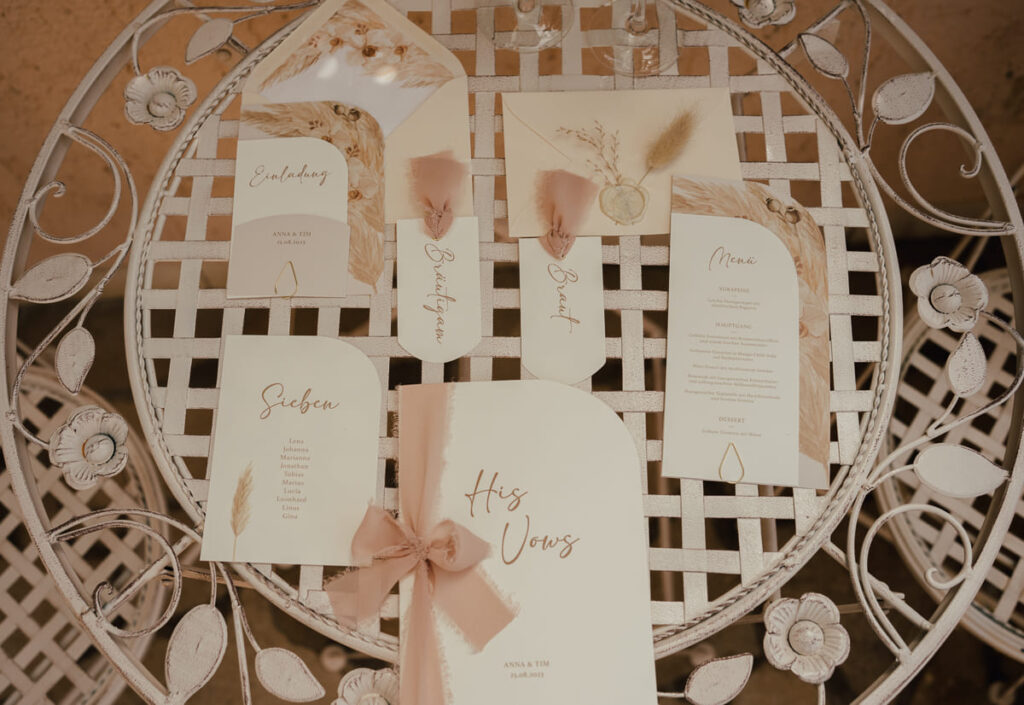 Hochzeitskarte und Papeterie auf einem Tisch liegend