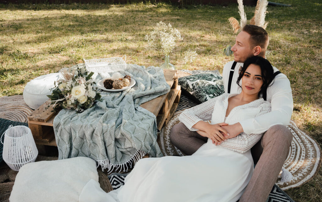 Brautpaar liegend bei einem Boho Styled Shooting auf einer Wiese im Altmühltal